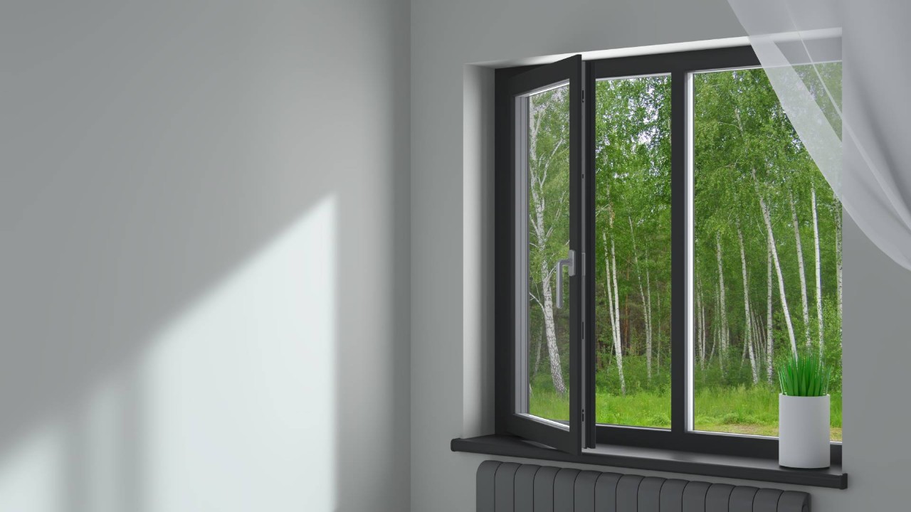 A black window frame in a bedroom with white walls in a home near Princeton and Hillsborough, NJ