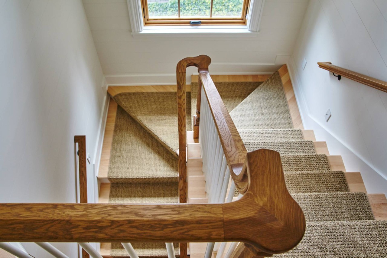 Top-down view of a wooden staircase with a carpet stair runner at Window Accents & Flooring near Princeton, NJ