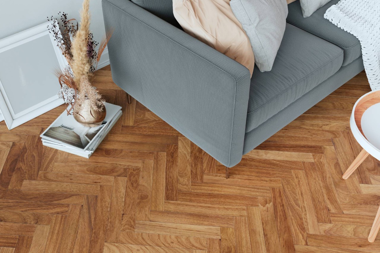 Hardwood flooring with a herringbone pattern in a living room featuring floor decor and a gray sofa near Princeton, New Jersey
